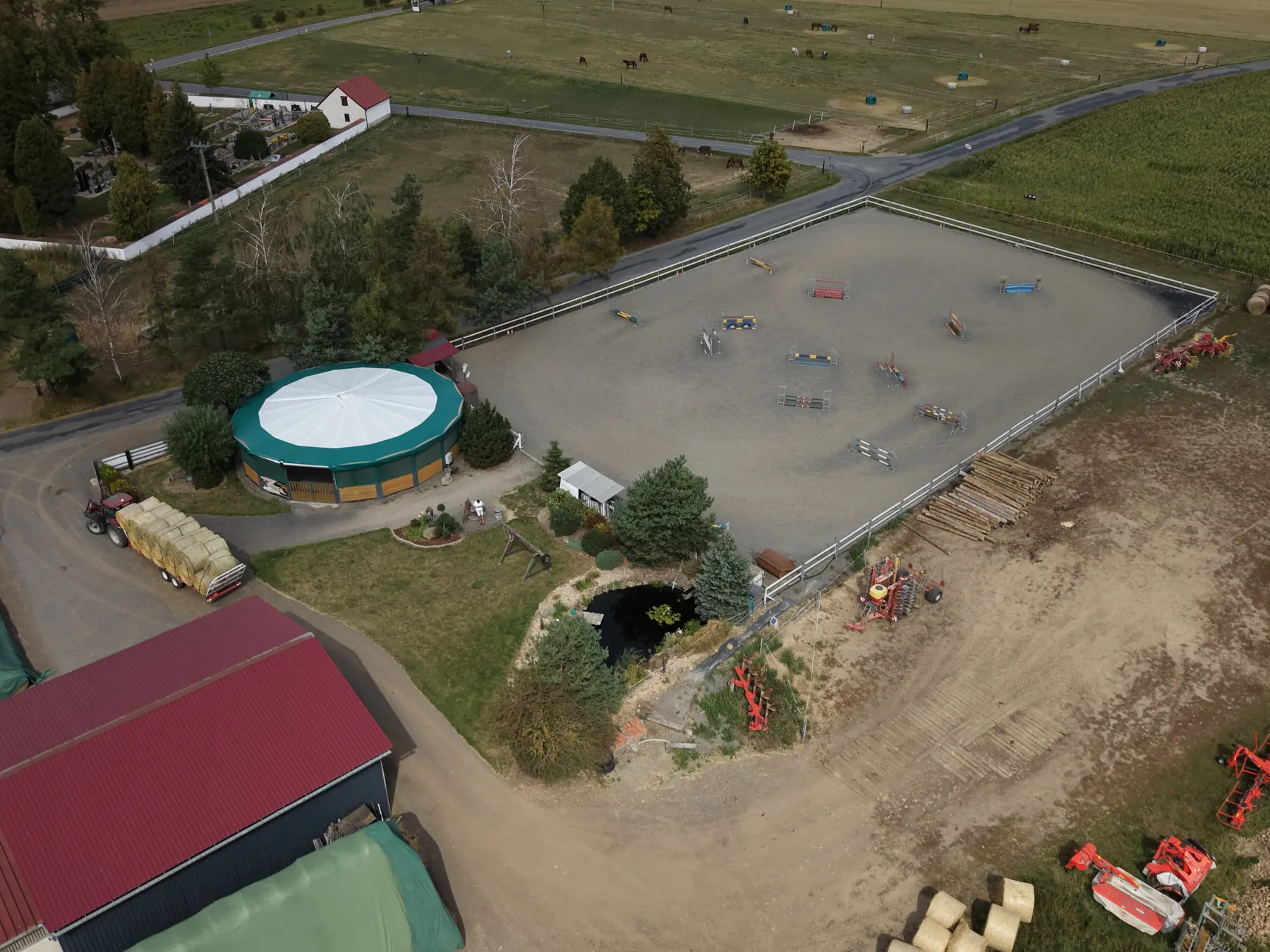 Areál farmy z dronu: jízdárna, krytá kruhovka a stáje